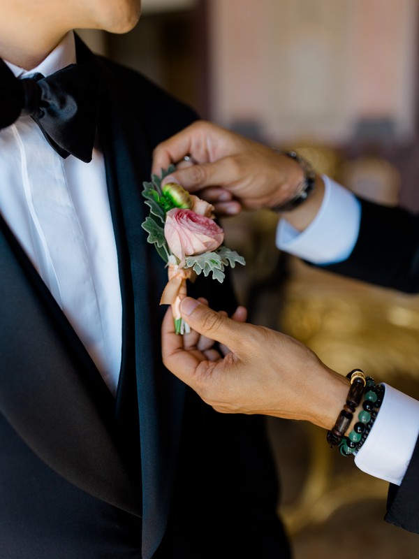 Wedding morning detail - boutonnière being pinned on Stefan's lapel in the Algarve